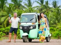 Hosts Stephanie Sitt and Luke Shantz rocking their tools with their Tuk Tuk, as seen on Betting on Paradise, Season 1.